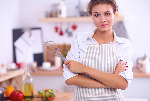 istock Smiling young woman in the kitchen,standing on christmas background 501058426