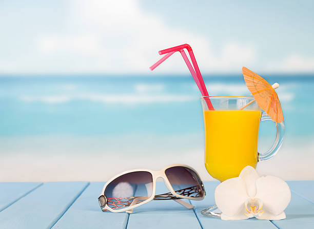 istock Sunglasses and cocktail with umbrella on sea background 501059702