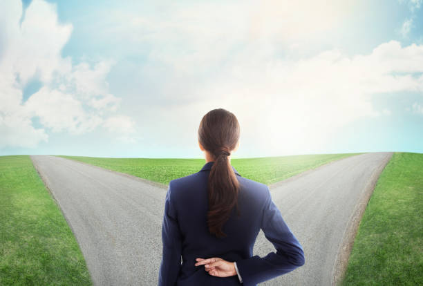 Don't let fear stop you on the road to success Concept shot of a young businesswoman at a crossroads crossing her fingershttp://195.154.178.81/DATA/i_collage/pi/shoots/783652.jpg fork in the road stock pictures, royalty-free photos & images