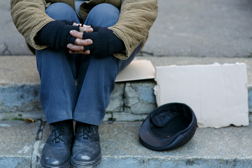 Asking for help. Depressed old beggar is sitting outside and waiting to get some help.