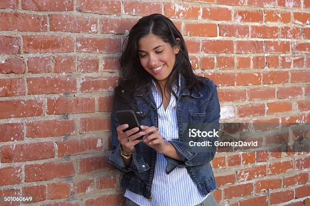 Attractive Young Latina Woman Listening To Music On Cell Phone Stock Photo - Download Image Now