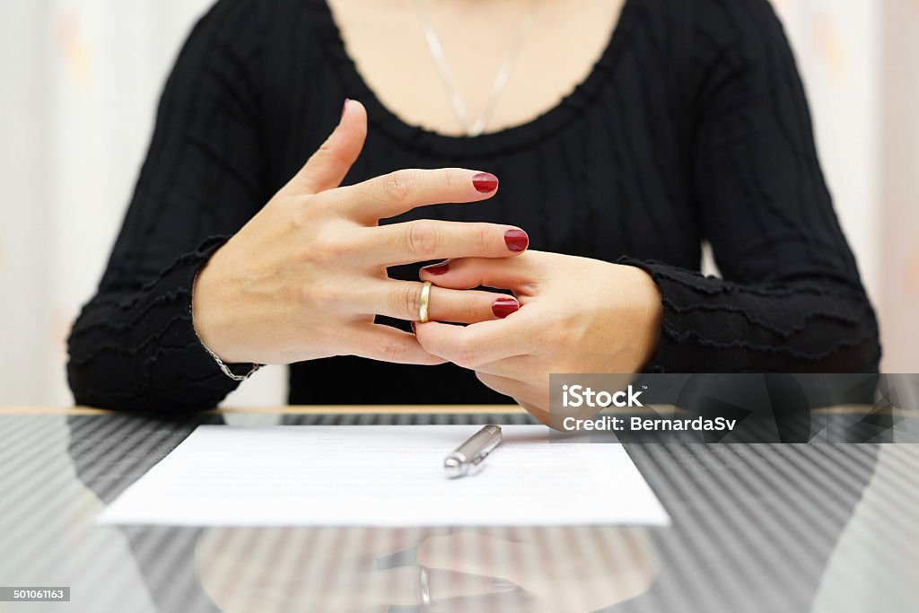 break up . Woman is taking off the ring from hand Adult Stock Photo