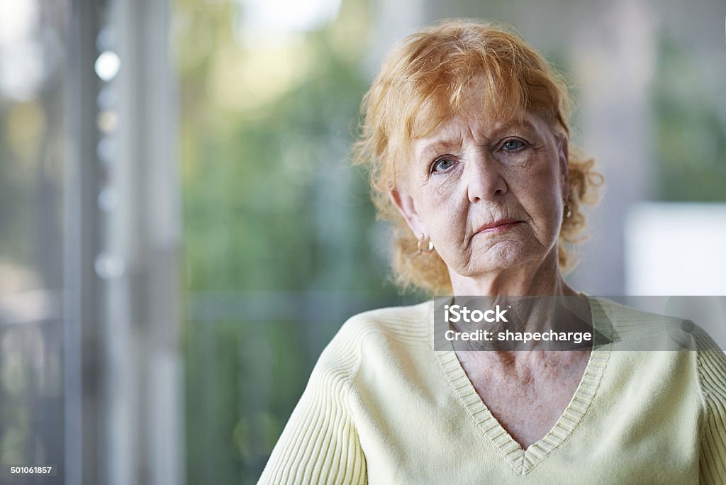 It can get a bit lonely around here A cropped portrait of an unhappy-looking elderly woman sitting on her porch at home Senior Women Stock Photo