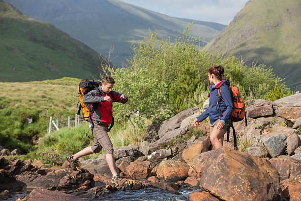 istock Couple crossing a river on hike 501063207