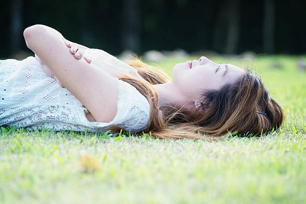istock asia beautiful young woman lying on green grass 501063346