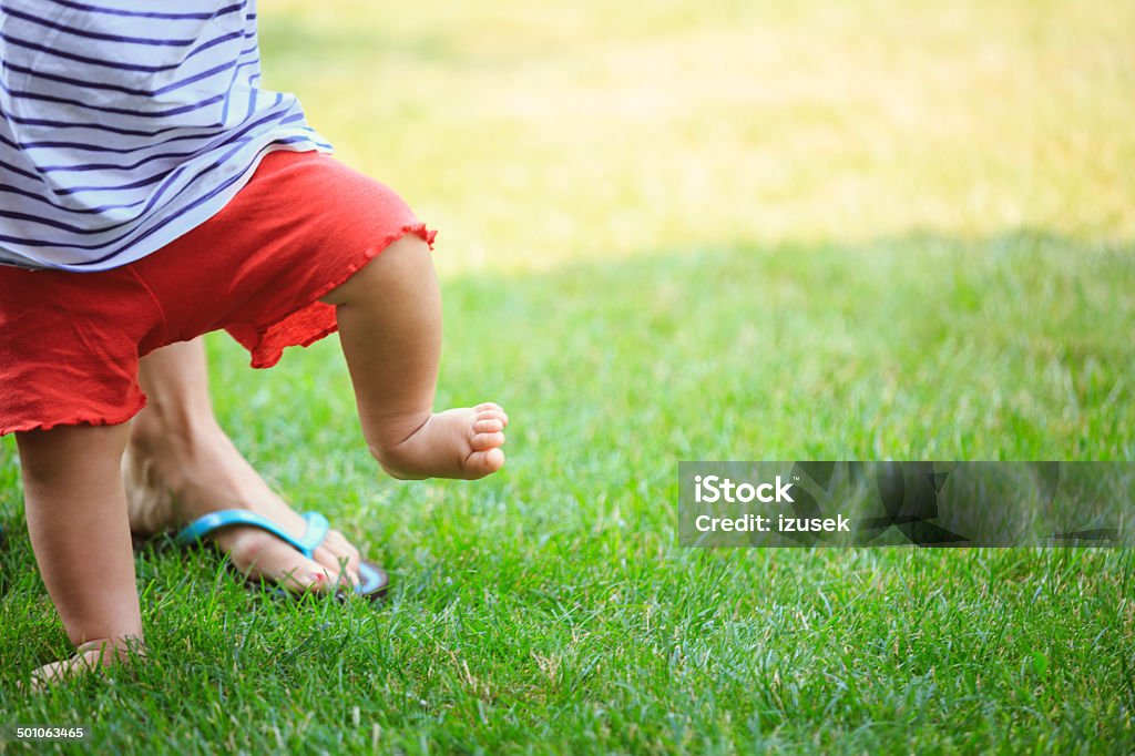First steps Baby's first steps on the grass.  Baby - Human Age Stock Photo