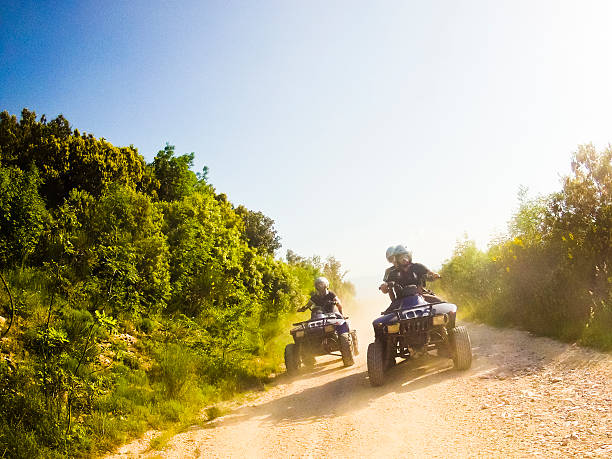 deux garçons sur quad vélo en montagne - monter un animal ou sur un moyen de transport photos et images de collection