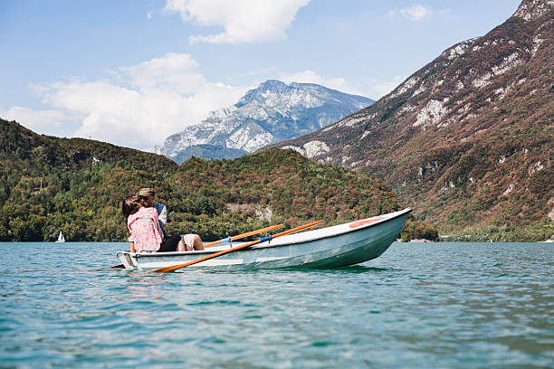 Couple relaxing on a small boat, during a sunny day on lake. Holiday!