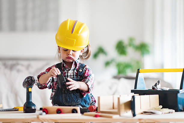 Little Girl Power Litte 2 years old girl who dreams of becoming a carpenter career girl stock pictures, royalty-free photos & images