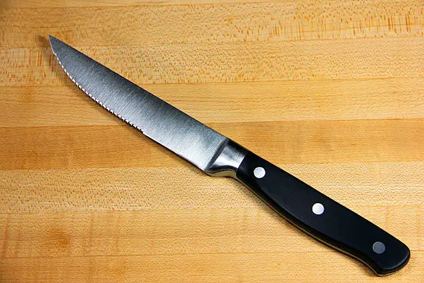 A steak knife on a cutting board