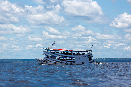 Manaus, Brazil - March 25, 2015: Typical wooden white Amazon boat sailing on Rio Negro near Manaus, Amazonas State. Brazil 2015