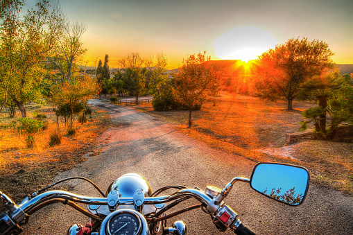 classic motorcycle on the edge of the road at sunset