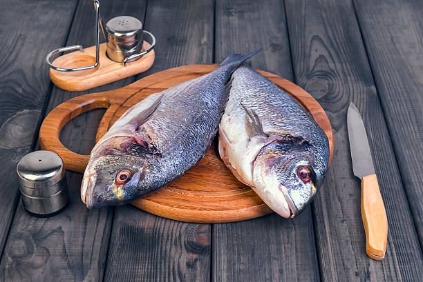 istock wooden table cutting board with fresh raw dorado fish 501067756