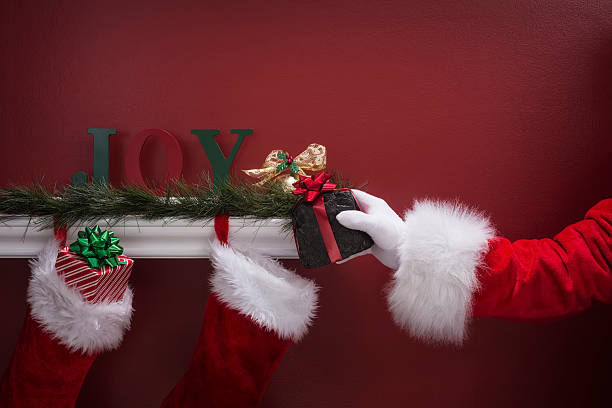 istock Santa's hand placing coal into Christmas Stockings 501068558
