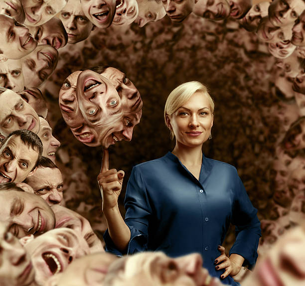 Businesswoman holding men's faces on the finger against men's heads