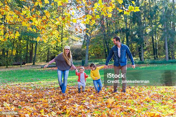 Family Walking On Leaves Stock Photo - Download Image Now - Active Lifestyle, Adult, Autumn