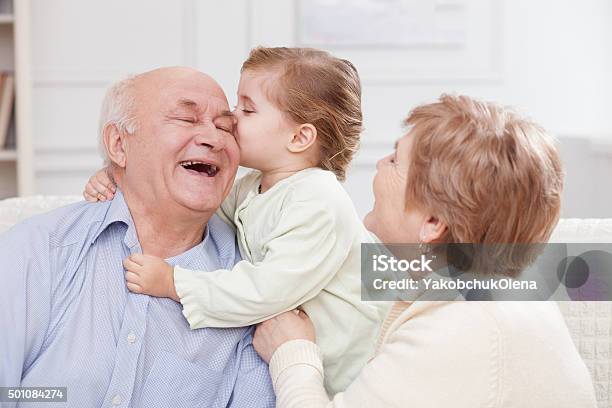 Cute Small Child Is Expressing Love To Grandparents Stock Photo - Download Image Now