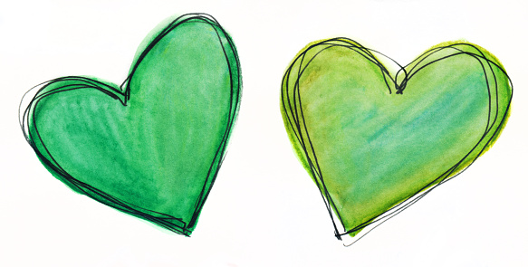 Hand painted hearts created with watercolors and ink. There are two hearts with multiple shades of green. They are outlined in black ink. They are isolated on a white background for copy space. There is a subtle texture in the paint.