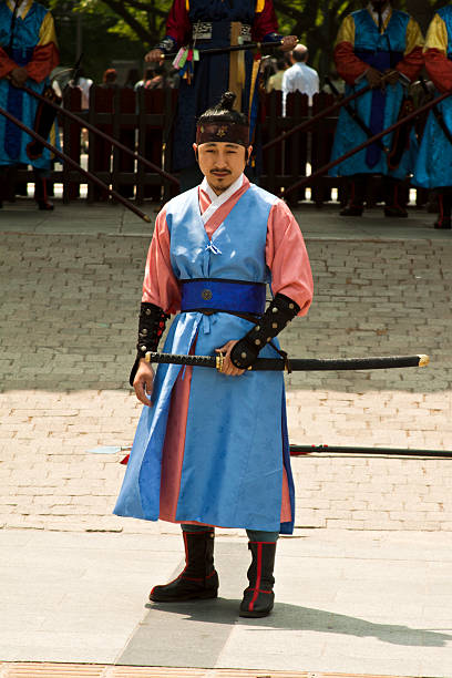 Armed guards in traditional costume Seoul, Korea - May 14, 2015:  Armed guards in traditional costume guard the entry gate at Deoksugung Palace, a tourist landmark, in Seoul, South Korea on May 14, 2015 shooting guard stock pictures, royalty-free photos & images