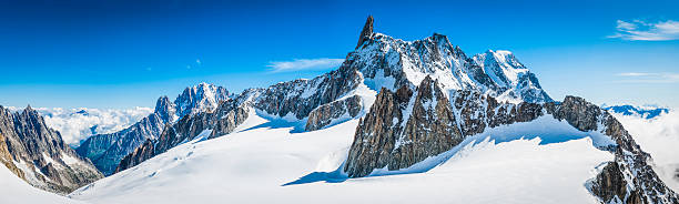 Alps jagged mountain peaks panorama above snowy Vallee Blanche Chamonix High altitude panoramic view above the clouds across the bright white glaciers, dramatic rocky pinnacles and high altitude summits of the Mont Blanc Massif and the Vallee Blanche from the Pointe Helbronner in Italy past the iconic Alpine peaks of the Aiguille du Midi to the Aiguille Verte and Les Drus, and down the Glacier du Geant down to the Chamonix valley in France. ProPhoto RGB profile for maximum color fidelity and gamut. aiguille de midi photos stock pictures, royalty-free photos & images