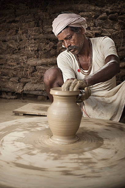 istock Traditional Indian potter making clay pot on manual pottery wheel. 501093886