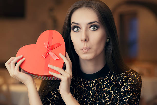 istock Surprised Beautiful Woman Holding Heart Shape Gift 501117056