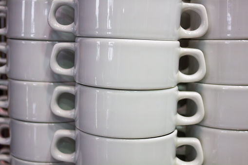 Pure white dishes is neatly standing in the cafe