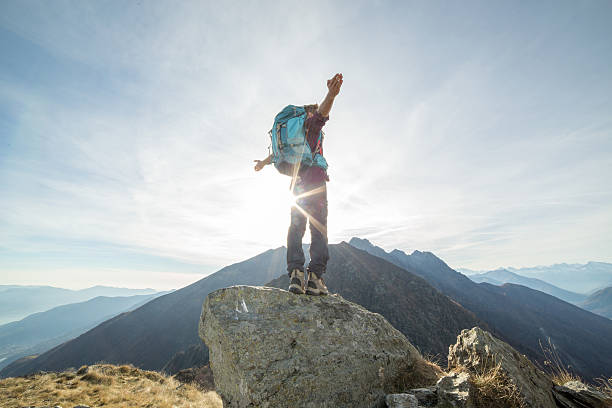 istock Hiker stretches arms to sunset, mountains 501119884