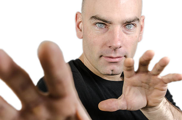 Man hypnotist with hands in front of camera, studio shot, white background.