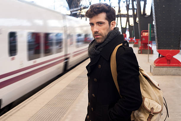 istock Young man waits for train in station 501125690