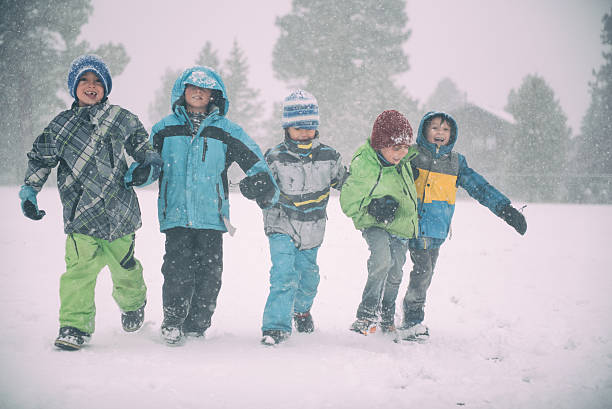 istock Children running and playing in the snow during a storm 501126108