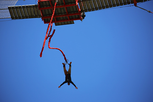 Soweto, South Africa - August 8, 2015: A person bungee jumps off of the cooling towers of the decommisioned Orlando Power Station in Soweto. For 56 years the plant supplied Johannesburg with electricity.