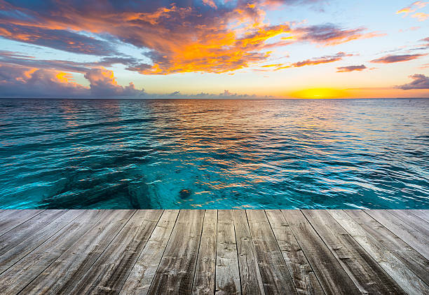 wooden deck at caribbean sea at sunset wooden deck at caribbean sea at sunset caribbean beach sunset stock pictures, royalty-free photos & images