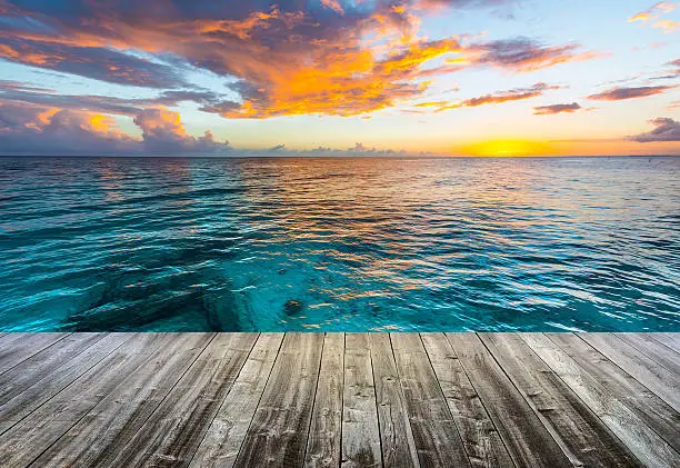 Photo of wooden deck at caribbean sea at sunset