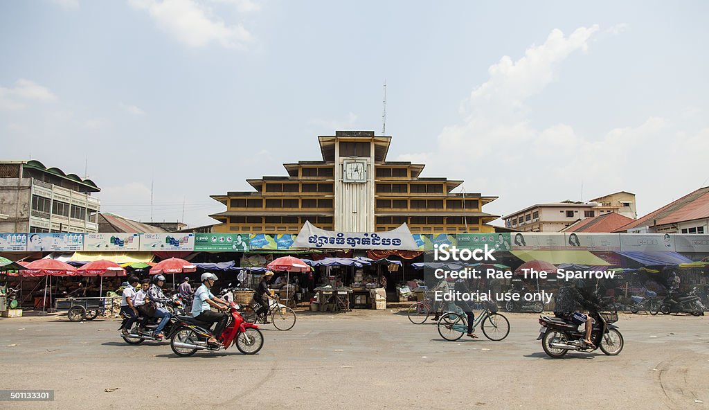 Battambang Market Battambang, Сambodia - February 28, 2014: locals ride bicycles and motorbikes past the old art deco market dating from the French colonial era. Architecture Stock Photo