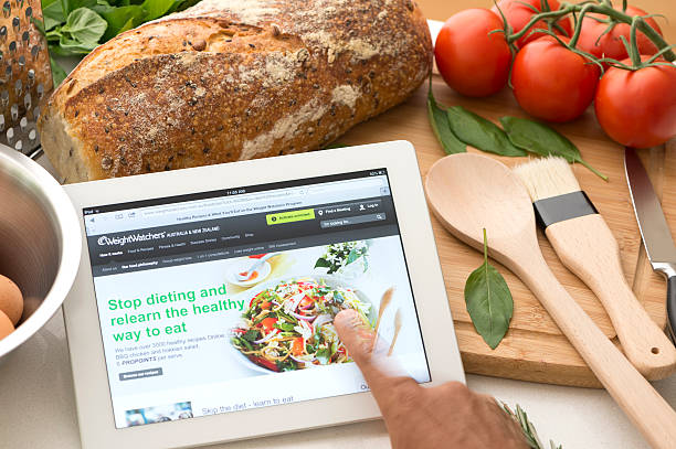 weightwatchers.com internetowej na tablet w kuchni - ipad apple computers digital tablet editorial zdjęcia i obrazy z banku zdjęć