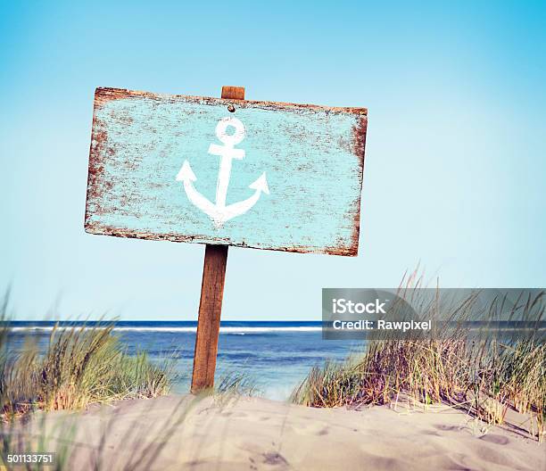 Blue Painted Wood Label On The Beach Stock Photo - Download Image Now - Beach Sign, Anchor - Vessel Part, Sign