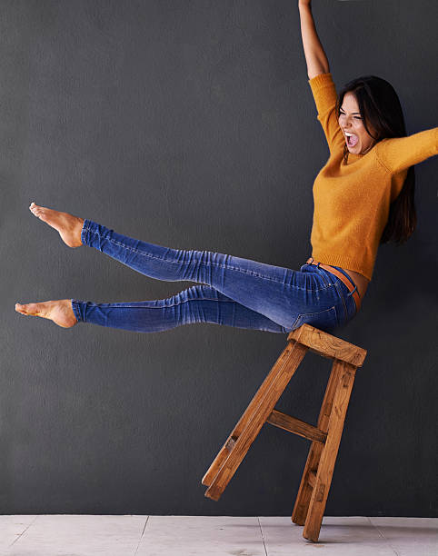 Living on the edge. Oh yeah! Shot of a happy young woman shouting while leaning back on a stoolhttp://195.154.178.81/DATA/i_collage/pi/shoots/783562.jpg person falling backwards stock pictures, royalty-free photos & images