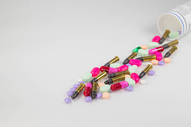 красочные таблетки и пуля на белом фоне - capsule vitamin pill red lecithin стоковые фото и изображения