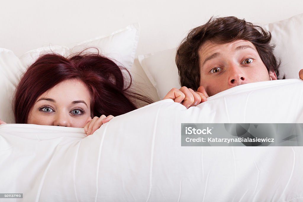 Couple surprised in bed Young attractive couple are surprised in bed together Adult Stock Photo