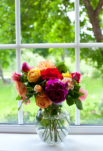 large vase with colorful roses on window sill