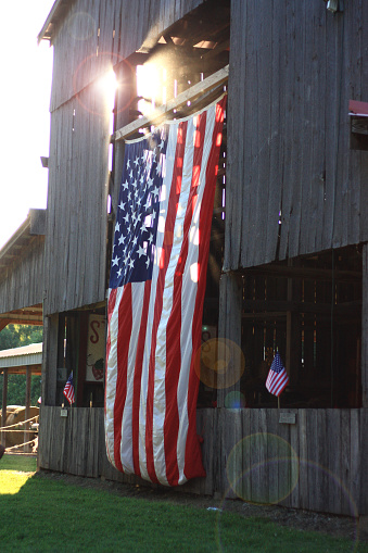 American flag hangs on a barn in the sunlight