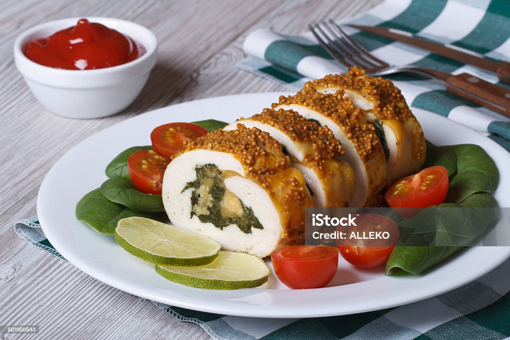 chicken breast stuffed with spinach and cheese on a plate chicken breast stuffed with spinach and cheese on a plate with vegetables and sauce. closeup horizontal Appetizer Stock Photo