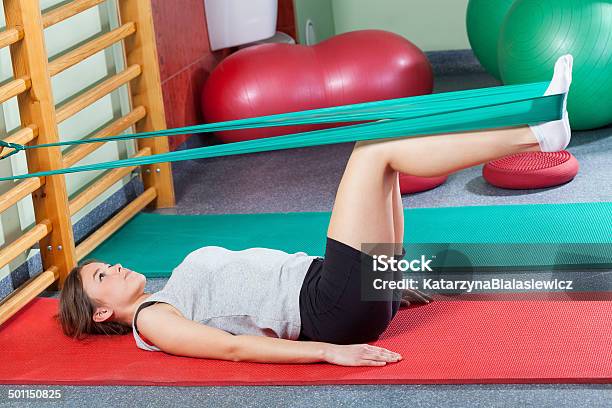 Girl Lying On Exercise Mat And Stretching Legs Stock Photo - Download Image Now - Exercising, Recovery, Active Lifestyle