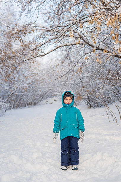 istock Cute little boy stands in winter park 501153252