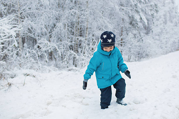 istock Cute little boy walks in a snow in the winter 501153384
