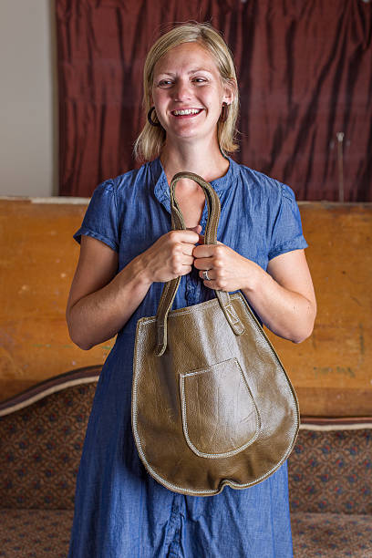 Smiling Blonde Woman With Green Leather Purse stock photo