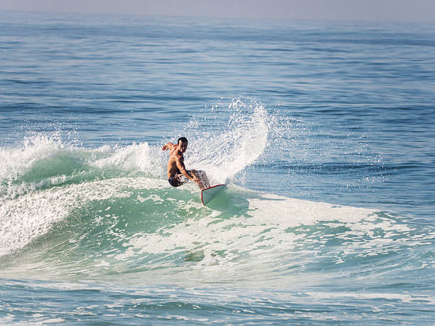 Young man riding a wave at sea and having fun.
