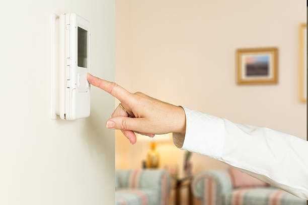 caucasianos lady pressionando moderno termostato - pushing women wall people imagens e fotografias de stock