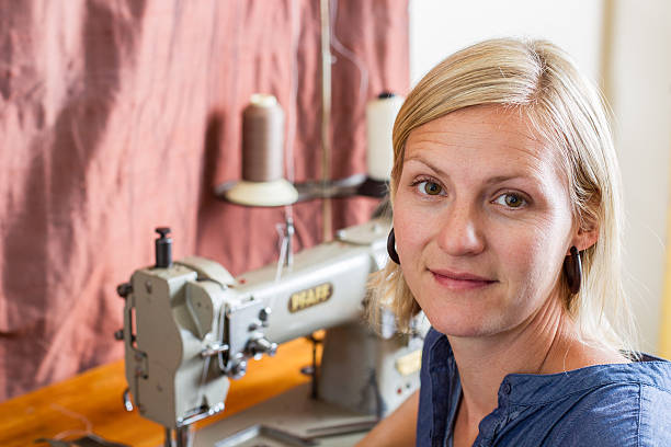 Pretty Blonde Woman At Sewing Machine stock photo